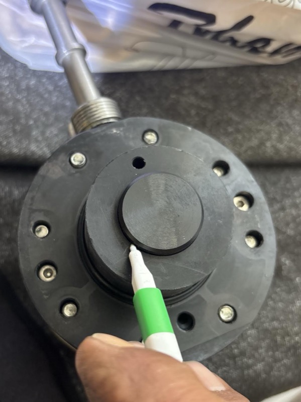 Technician indicating the diaphragm plate on a pump head